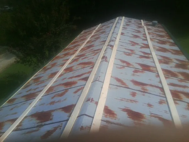Rusted metal roof panels with new wood purlins before replacement — Storm Damage Roof Repair in Buena Park by Roofing Brothers